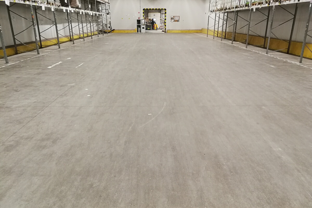 Polerowanie betonu w strefie chłodniczej centrum dystrybucyjnego Netto — renowacja Silicol Renova w niskiej temperaturze